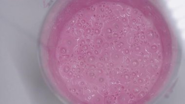 Hazırlık aşamasında doku ve tutarlılığı gösteren küçük kabarcıklarla dolu pembe silikon karışımının üst görünümü