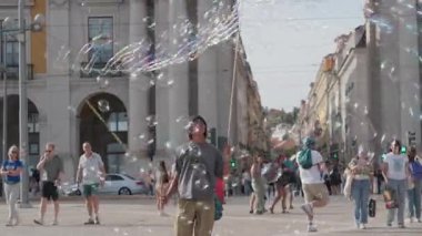 Portekiz, Lizbon 25 Haziran 2025 sokak sanatçısı Lizbon, Portekiz 'deki kalabalık meydanda kalabalığa neşe getirdi. Baloncuklar yükselirken insanlar sanatsal gösterinin tadını çıkarmak ve izlemek için toplanıyor.