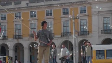 Portekiz, Lizbon 25 Haziran 2025 yetenekli balon sanatçısı Lizbon ticari meydanındaki kalabalığı eğlendiriyor etkileyici kabarcık numaraları sergiliyor.