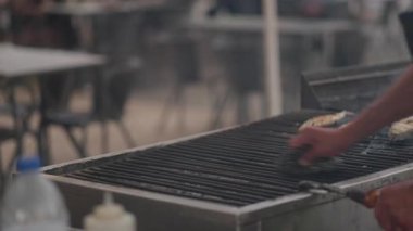 Yerel bir şef, Lizbon, Portekiz 'de bir sokakta ustalıkla balık pişiriyor. Havayı enfes bir koku kapladıkça duman yükselir, geçenleri cezbeder ve canlı atmosferden zevk alırlar..