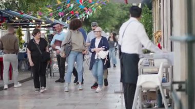 Portekiz, Lizbon 25 Haziran 2025 İnsanlar Lizbon, Portekiz 'de canlı bir caddede yürüyorlar. Bireyler dışarıda eğlenirken renkli dekorasyonlar neşeli çevreye katkı sağlıyor..