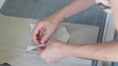 Eller, basit dikiş tekniklerini kullanarak ustalıkla bir kumaş kesesi oluşturur. Malzemelerin her durum için mükemmel bir aksesuar oluşturmasını izleyin..