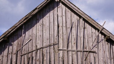 Çatının tepesindeki eski ahşap bir ahırın sonunda, gri, solgun eski tahtalar..