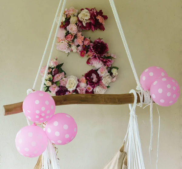 Pembe balonlar ve bir çocuğun doğum günü partisi için çiçeklerle süslenmiş beş balon..