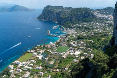 Capri, Italy - 04.29.2025: Beautiful general scenic view from a high viewpoint of the island of Capri and the sea; part of the harbor is visible.
