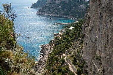Capri, İtalya - 04.29.2025: Capri adasının kayalık kıyıları ve yüksek perspektiften bakan mavi deniz suları.