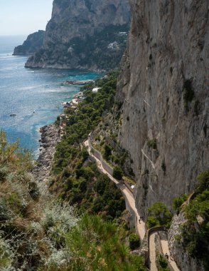Capri, İtalya - 04.29.2025: Capri adasının kayalık kıyıları ve yüksek perspektiften bakan mavi deniz suları.
