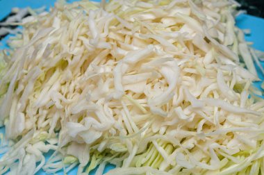 Kesme tahtasında parçalanmış beyaz lahana.