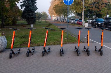Elektrikli scooterlar sıraya dizildi. Caddedeki elektrikli scooter kiralama istasyonu.