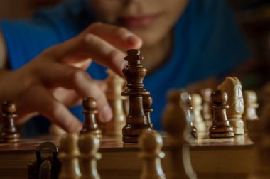 Bir çocuk satranç oynar. Ön plana odaklan. Yüksek kalite fotoğraf