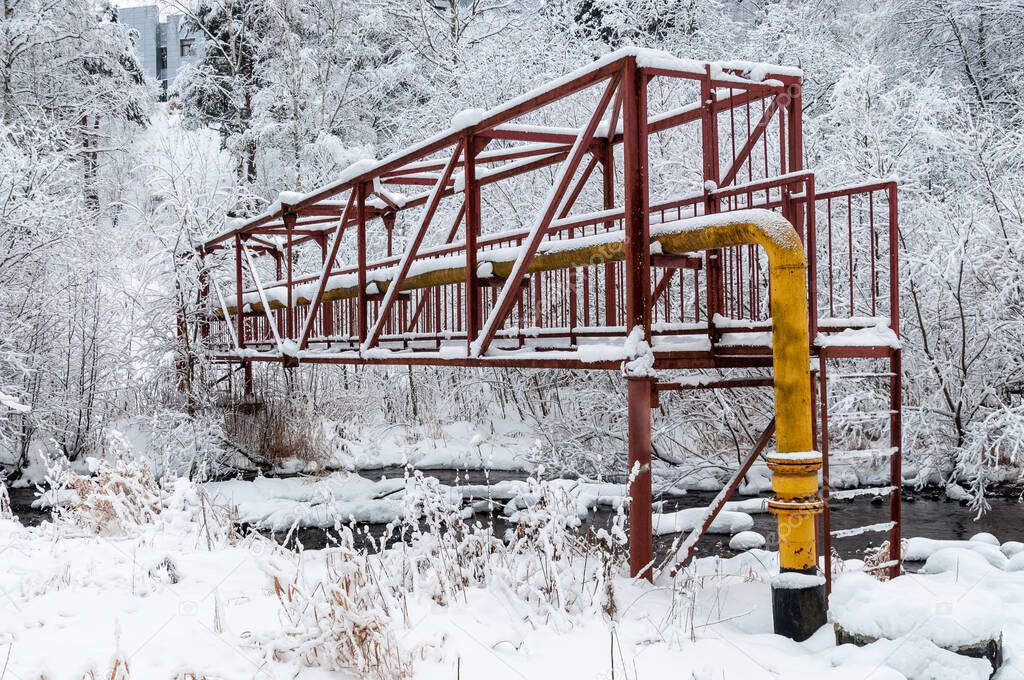gas pipeline through a small river in the winter forest. High quality photo
