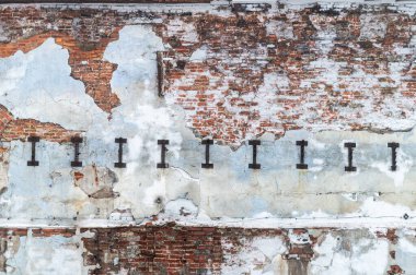 Kısmen çökmüş alçılı eski bir tuğla duvarın dokusu