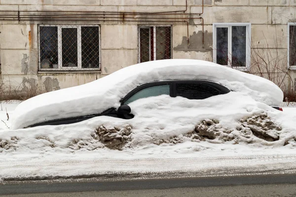 Coche abandonado en el lado de la carretera bajo una deriva de nieve —  Fotos de Stock