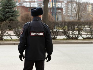 Bir Rus polisinin yoldaki görüntüsü. Üniformanın üzerindeki yazı polis anlamına geliyor.