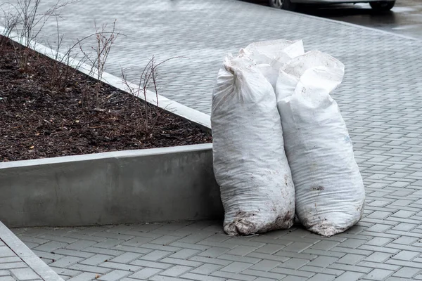 Temiz kaldırımda çöp dolu birkaç büyük beyaz plastik torba. Yüksek kalite fotoğraf