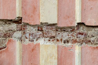 Binanın hasarlı cephesi. Tuğla işi alçı tabakasının altında görülebilir. Yüksek kalite fotoğraf