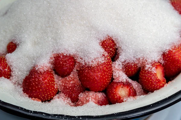 Çilekler şekerle kaplıdır. Çilek reçeli hazırlıyorum. Yüksek kalite fotoğraf