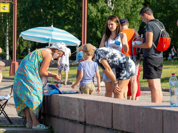 Петрозаводск, Россия - 18 июля 2021 г. Уличная торговля. группа людей возле женщины, продающей ювелирные изделия ручной работы