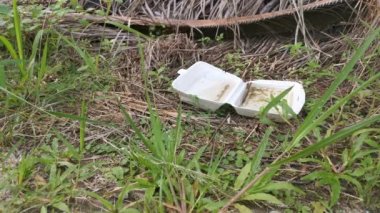 Atılan beyaz polistiren yiyecek kutusunun yağmur suyu topladığı görüntüler.