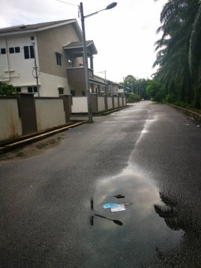 Su birikintisinin etrafındaki sokak manzarası.