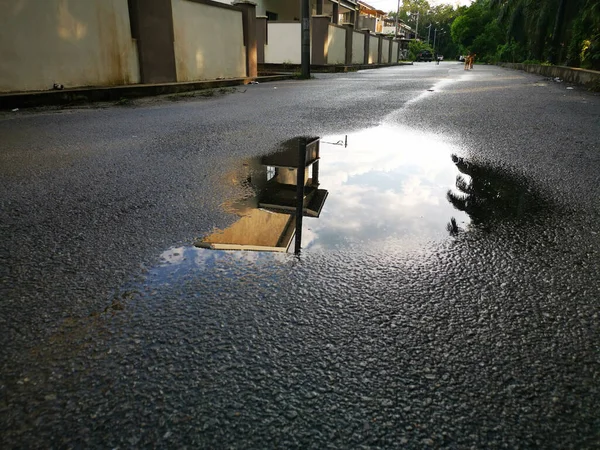 Su birikintisinin etrafındaki sokak manzarası.