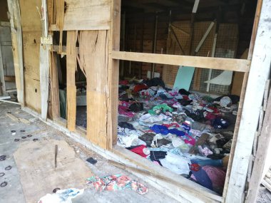 Perak, Malezya. 18 Kasım 2020: Kg Koh Palm çiftliğindeki terk edilmiş ahşap evde bulunan düzensiz kirli çamaşırlarla dolu bir kirli oda.