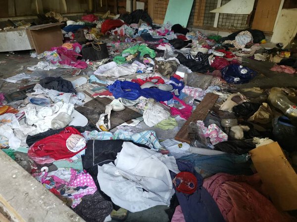 Перак, Малайзия. 18 ноября 2020 г.: Незанятая грязная комната, заполненная неорганизованной грязной одеждой, расположенная в заброшенном деревянном доме на плантации Kg Koh Palm.