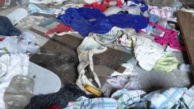 Perak, Malezya. 18 Kasım 2020: Kg Koh Palm çiftliğindeki terk edilmiş ahşap evde bulunan düzensiz kirli giysilerle dolu işlenmemiş kirli karanlık oda.