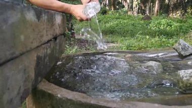 Havuz yüzeyindeki plastik şişeden su dökerken suyun yavaş yavaş sıçraması..