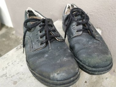 Aşınmış bir adamın siyah deri ayakkabısı..