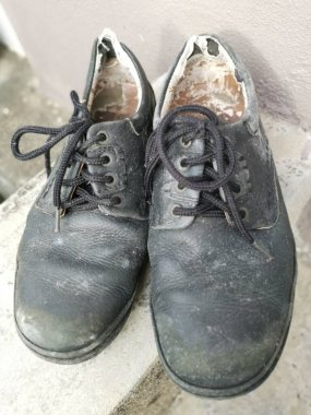 Aşınmış bir adamın siyah deri ayakkabısı..