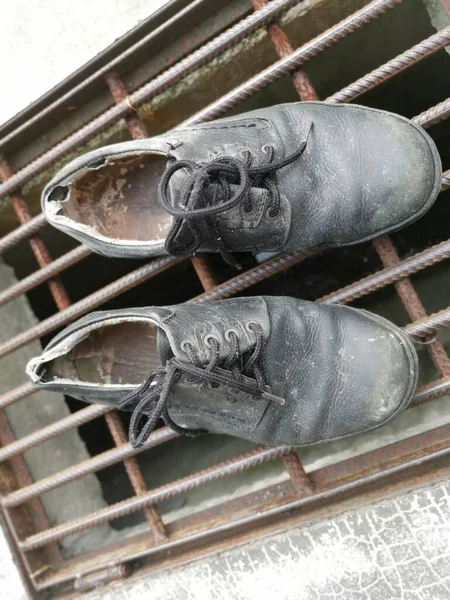 worn out man\'s black leather shoe.