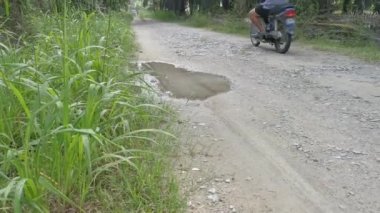 Perak, Malezya. 31 Aralık 2020: Kampong Koh Oil Palm Tarım Çiftliği kırsal yol üzerinde seyahat eden yerel motosiklet manzarası.