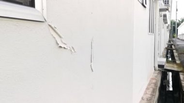 Duvardaki beyaz boyanın kabuğu soyulmuş..