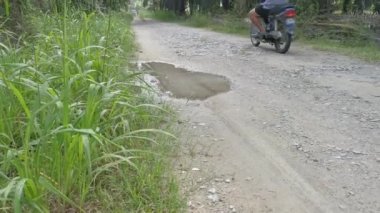 Perak, Malezya. 31 Aralık 2020: Kampong Koh Oil Palm Tarım Çiftliği kırsal yol üzerinde seyahat eden yerel motosiklet manzarası.