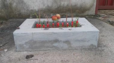 Çinlilerin tanrılarına saygı duymaları için yanan tütsü için basit bir dikdörtgen beton tur..