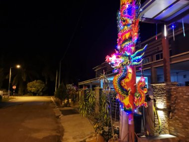 Büyük, yanmamış tütsülenmiş çubuk ışığı evin dışındaki gece sahnesini aydınlatıyor.. 