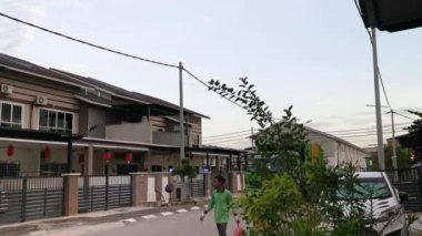 Perak, Malezya. Nisan 12, 2021: Atık toplama kamyonu ve işçiler Mas yerleşim bölgesi Kg Koh 'un sokağındaki çöp bidonlarında çöp topluyorlar.