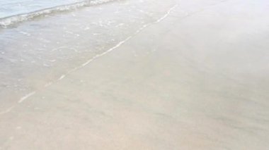 daytime scene of the sea wave moving onto the sandy beach
