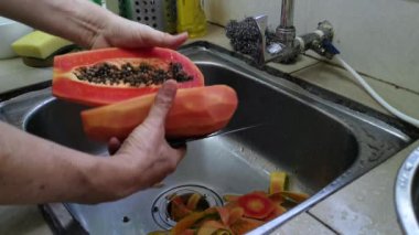 Olgun papaya meyvelerini soymak, temizlemek ve dilimlemek..