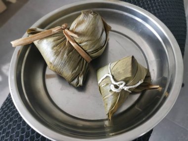 Pişmiş ve bambu yapraklı Çin böreği ile sarılmış.