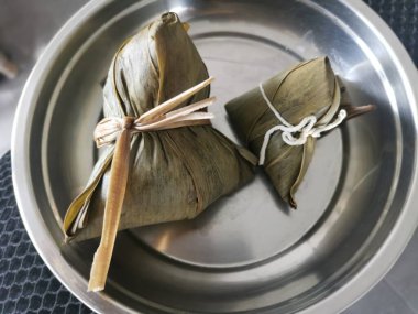 Pişmiş ve bambu yapraklı Çin böreği ile sarılmış.