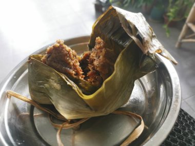 Pişmiş ve bambu yapraklı Çin böreği ile sarılmış.