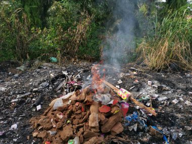 Kırsal yol boyunca yanan çöpler..