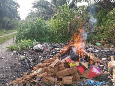 Kırsal yol boyunca yanan çöpler..