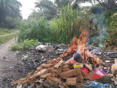 Kırsal yol boyunca yanan çöpler..