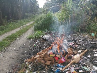Kırsal yol boyunca yanan çöpler..