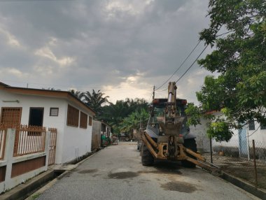 Kazı aracı izole yol kenarına park edilmiş.