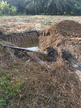 Traktör karada yağmur suyu dolu bir hendek kazdı.