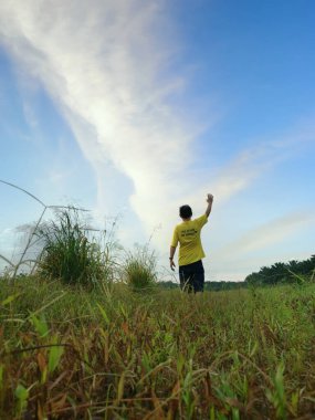 Sahadaki adam güzel gökyüzüne bakıyor.